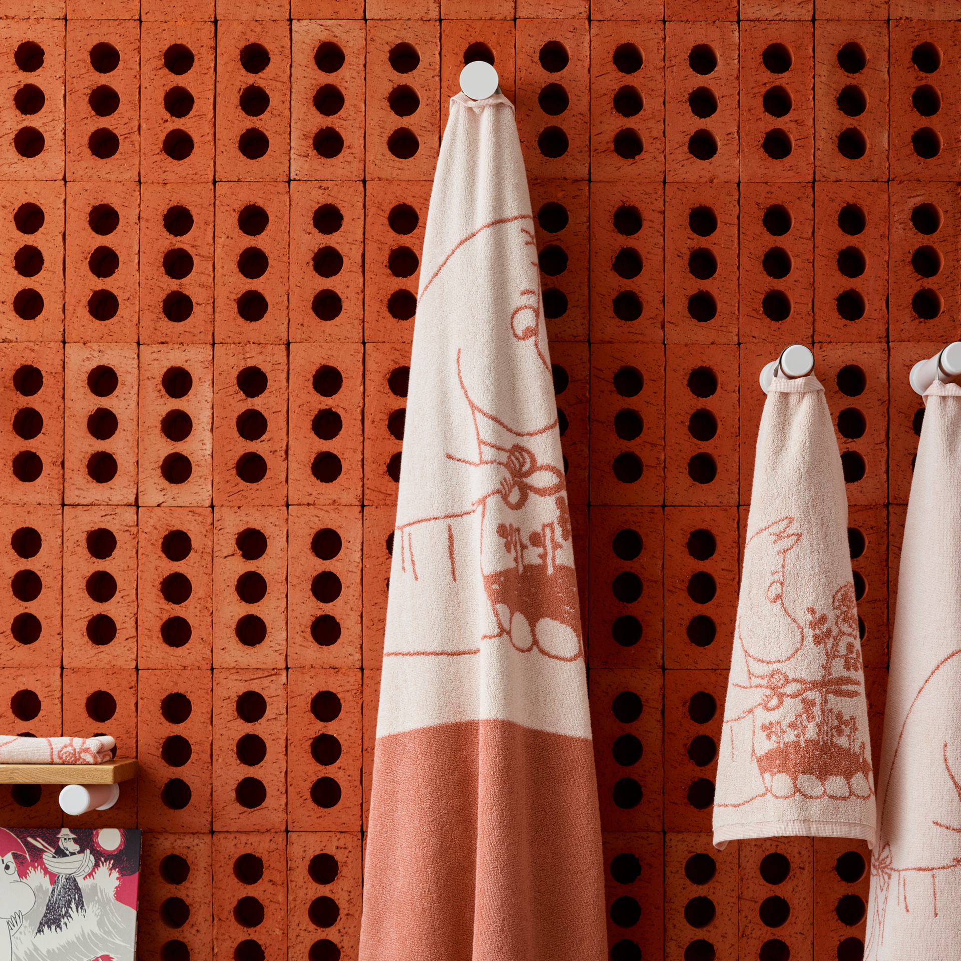 Muminbadhandduk 70x140cm Muminmamma beige - Moominmamma beige towels hanging in a bathroom.