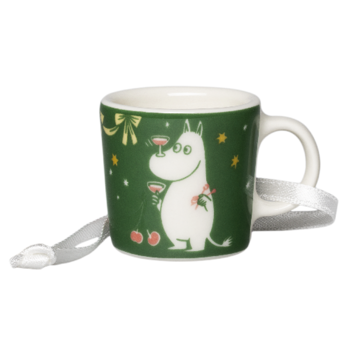 A green ceramic mini mug featuring a Moomintroll holding a drink, decorated with gold stars and a white ribbon tied around its handle, on a plain white background.