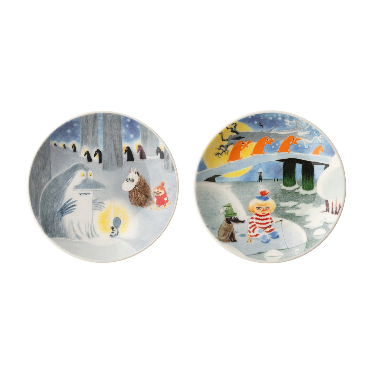Two round ceramic mini plates with winter-themed illustrations, shown side by side on a plain white background. The left plate depicts a snowy scene with the Groke, Moomintroll and Little My, while the right plate shows a snowy landscape with Too-ticky.