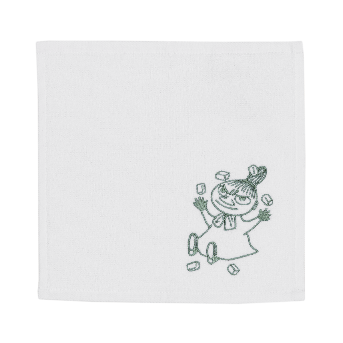 A white square table featuring a small dark green embroidered illustration of a Little My in the lower right corner.