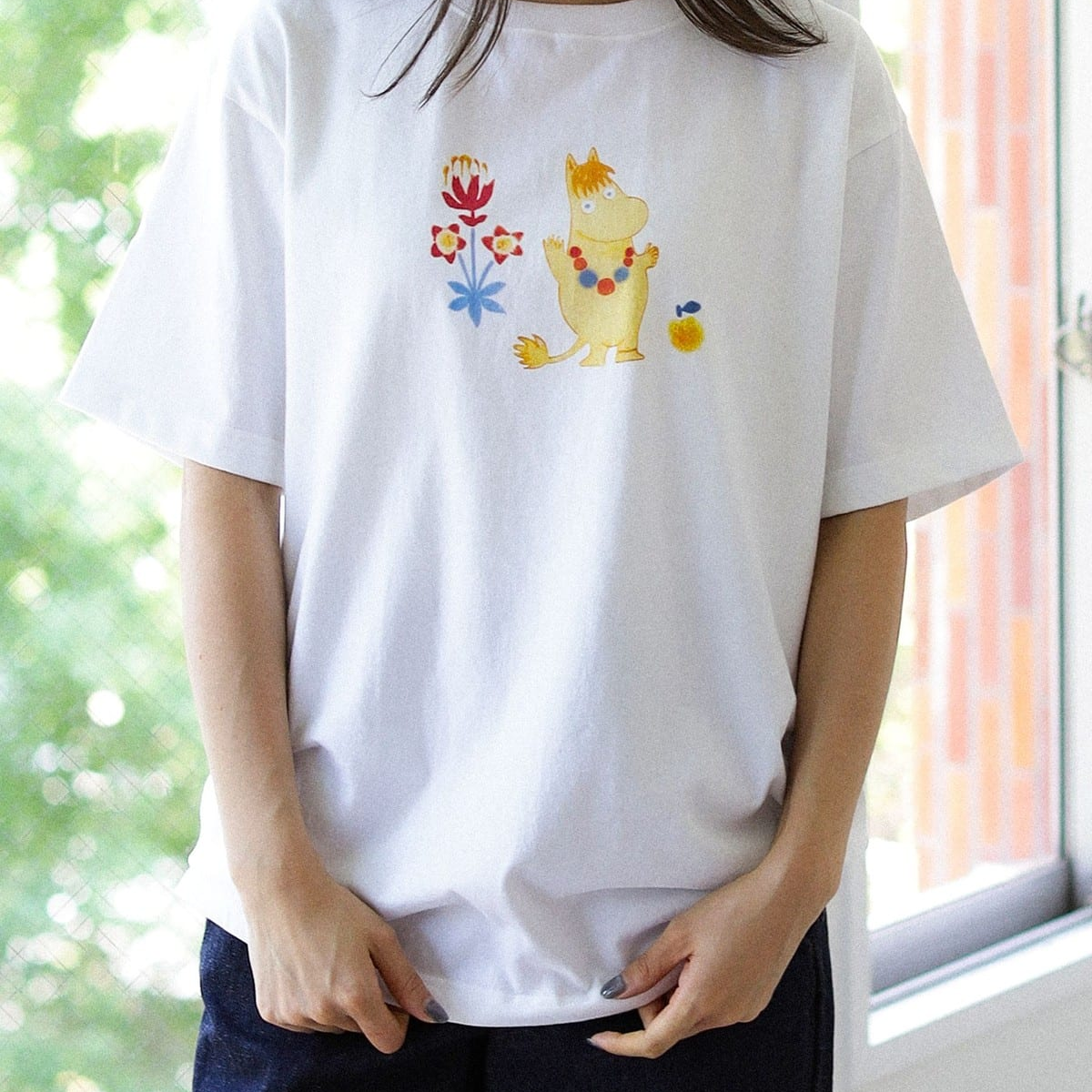 Mummi T-skjorte Snorkfrøken L Beams - White t-shirt with a colorful Snorkmaiden design worn by a person, with a blurred background.