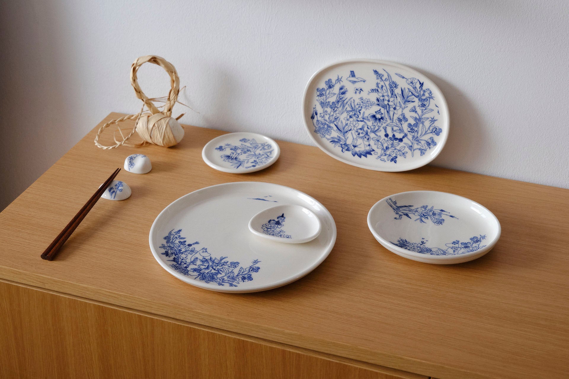Set of white ceramic Haru plates with blue floral patterns on a wooden surface.