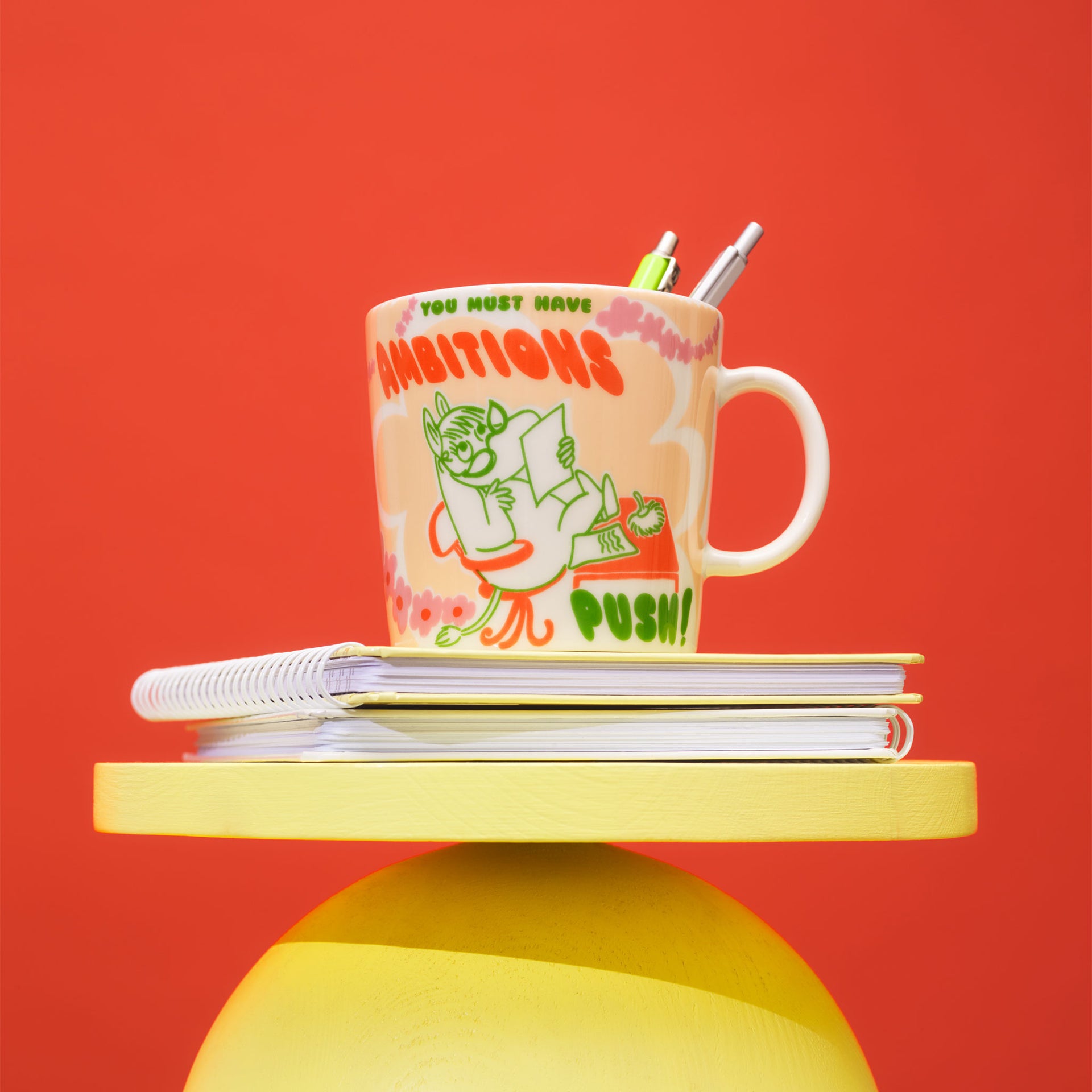 Boss Lady mug on top of two notebooks  on a red background