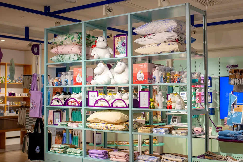 Display case with various moomin characters stuffed animals and products in a moomin arabia store
