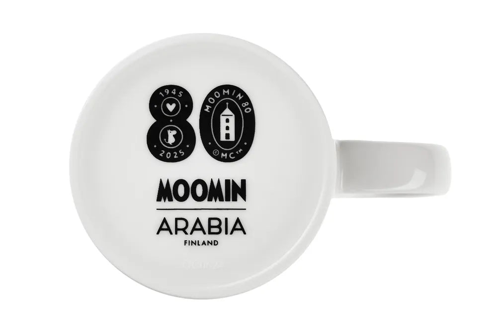 White mug with Moomin 80-anniversary stamp and Moomin Arabia logo at the bottom