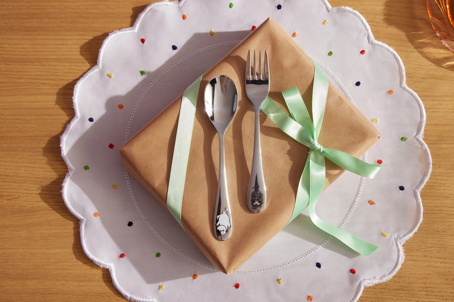 moomin arabia childrens' cutlery on top of a paper-wrapped gift on a table