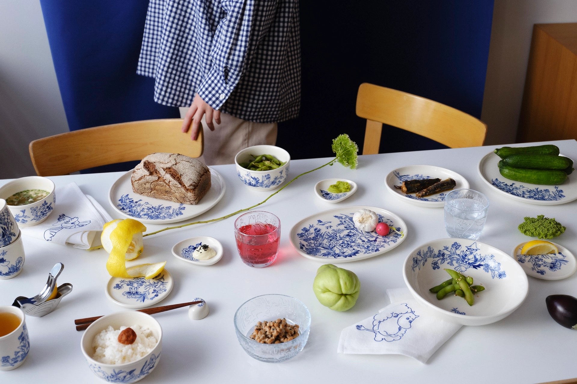 Table set with various Haru collection dishes and a person standing behind it